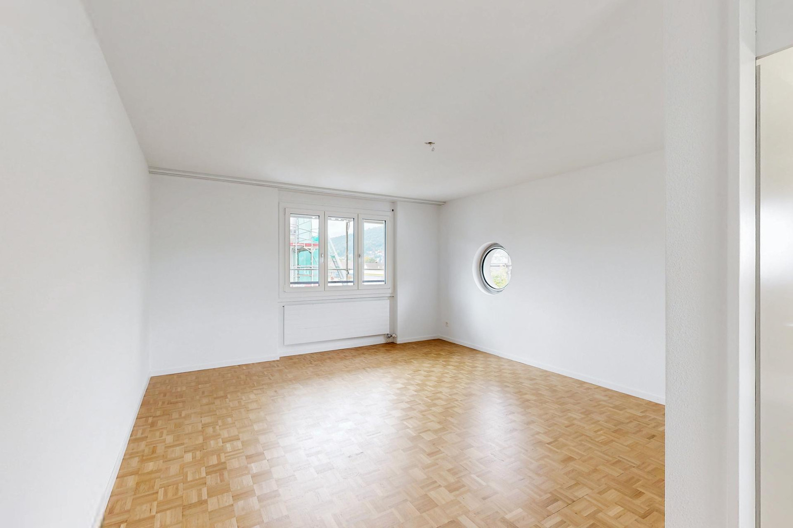 Heller, leerer Raum mit Parkettboden