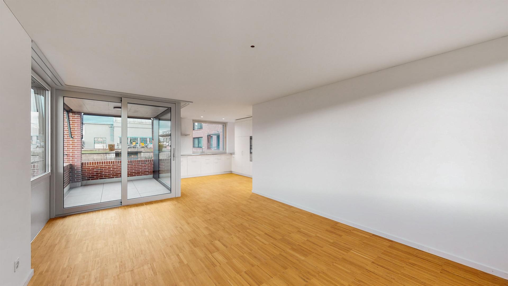 Heller Wohnraum mit Balkon und offener Küchenzone