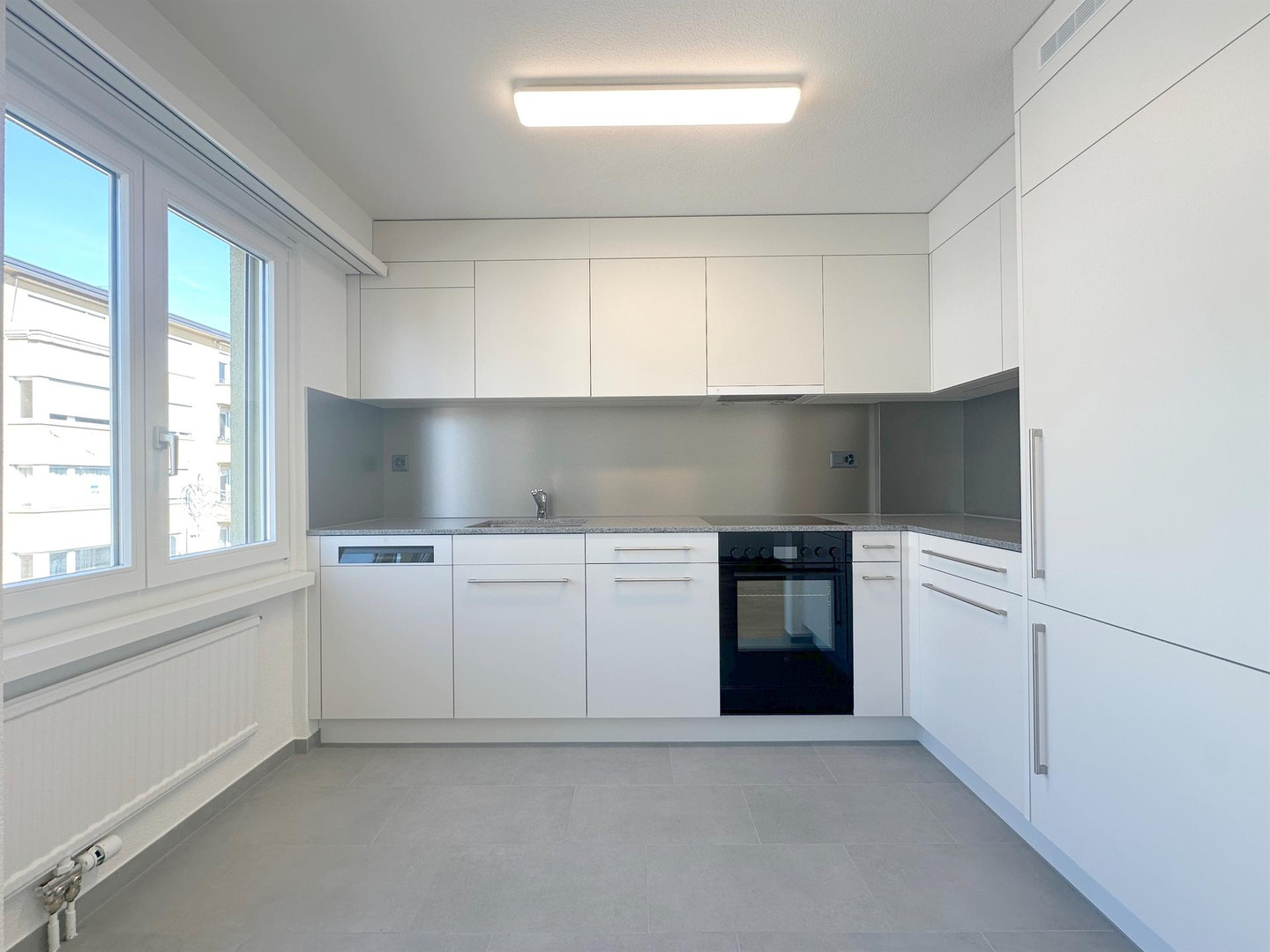 Moderne weiße Einbauküche mit Fenster