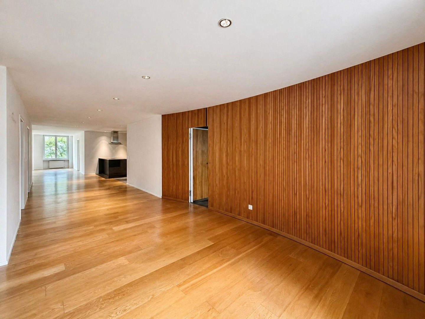 Großer leerer Wohnbereich mit Holzverkleidung