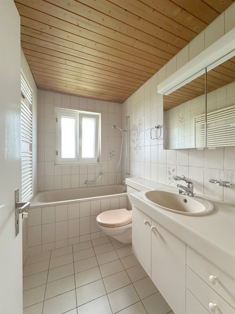 Badezimmer mit Badewanne und Holzdecke