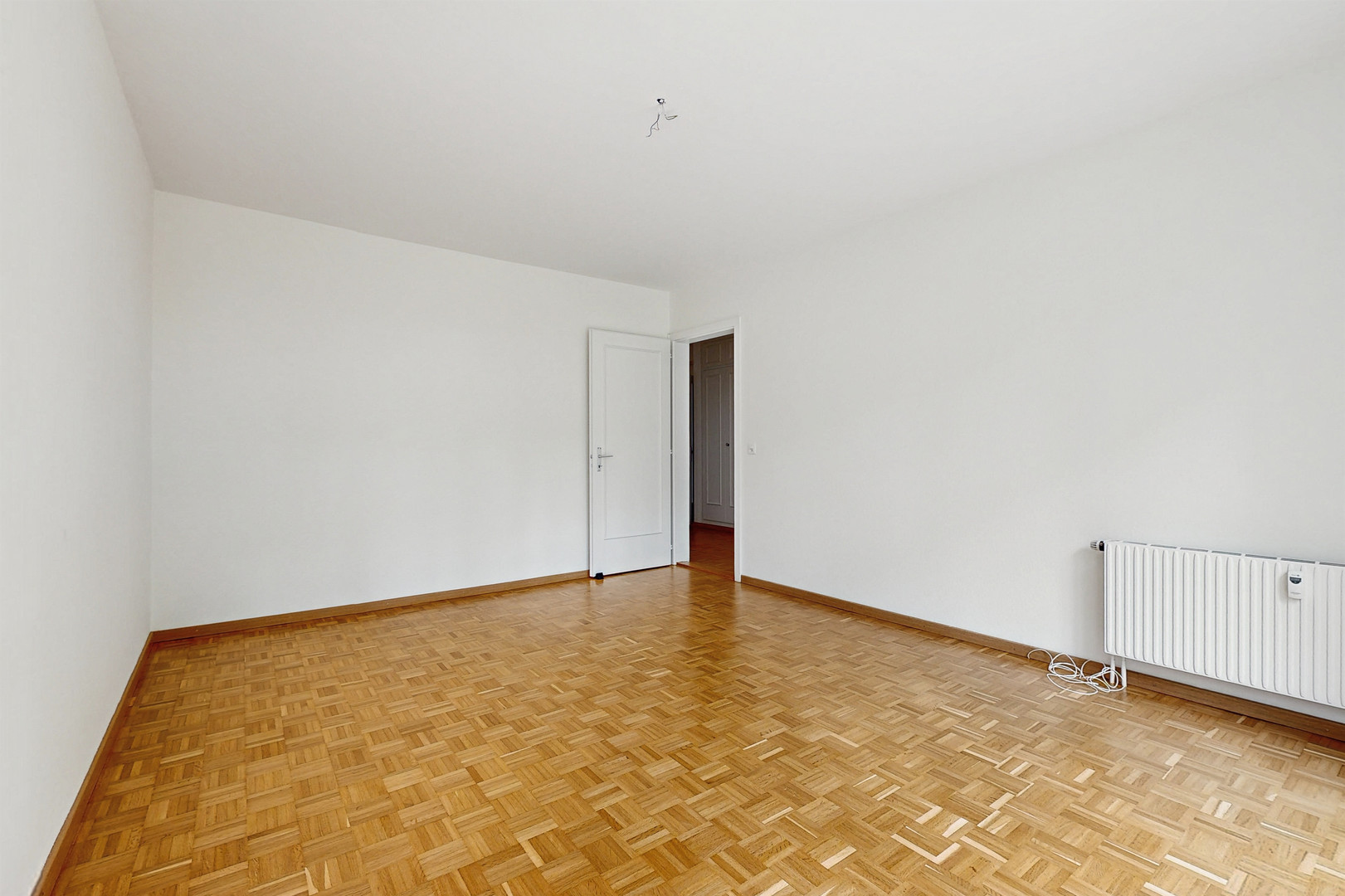Leerer, heller Raum mit Parkettboden