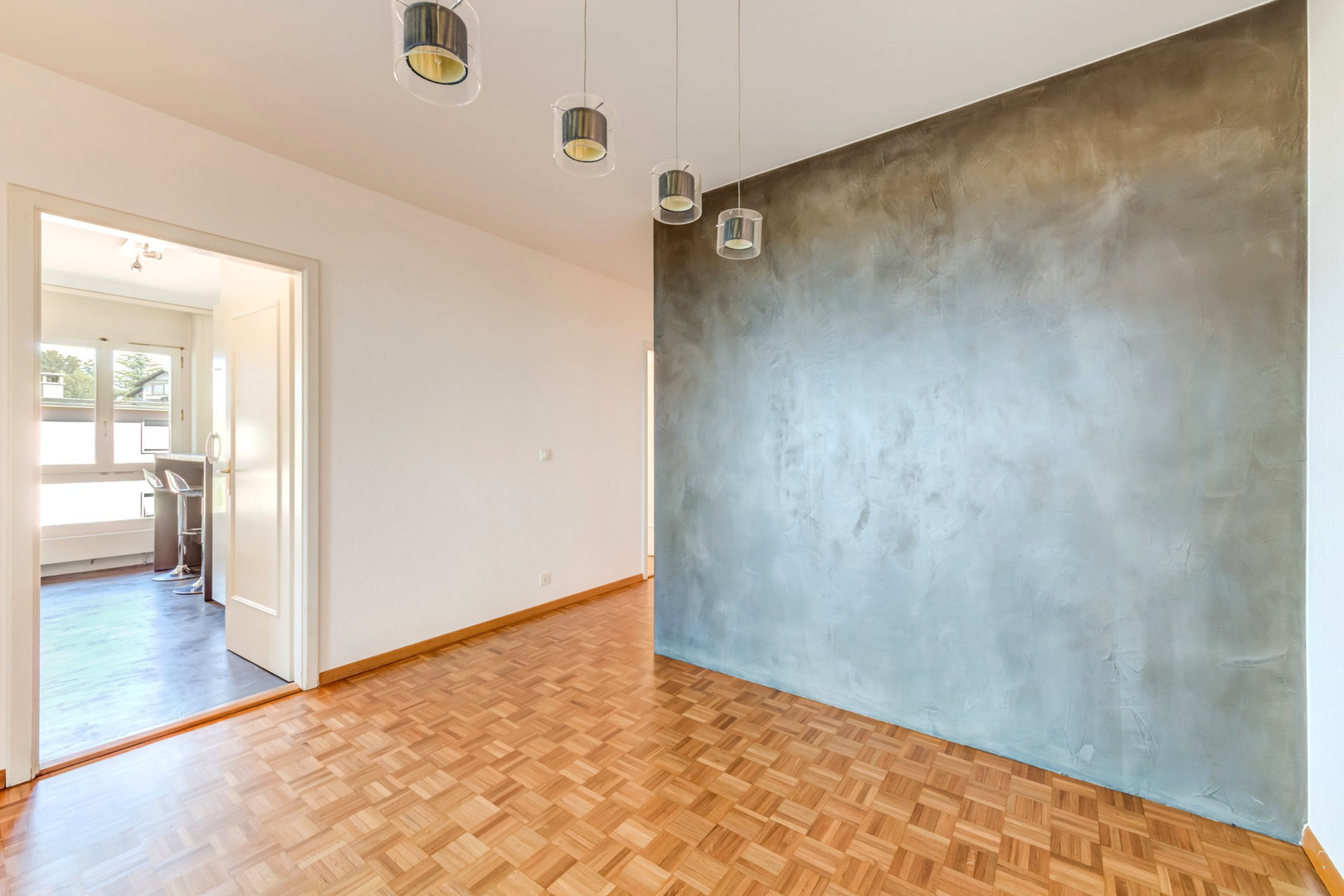 Helles Zimmer mit Holzparkett und Akzentwand