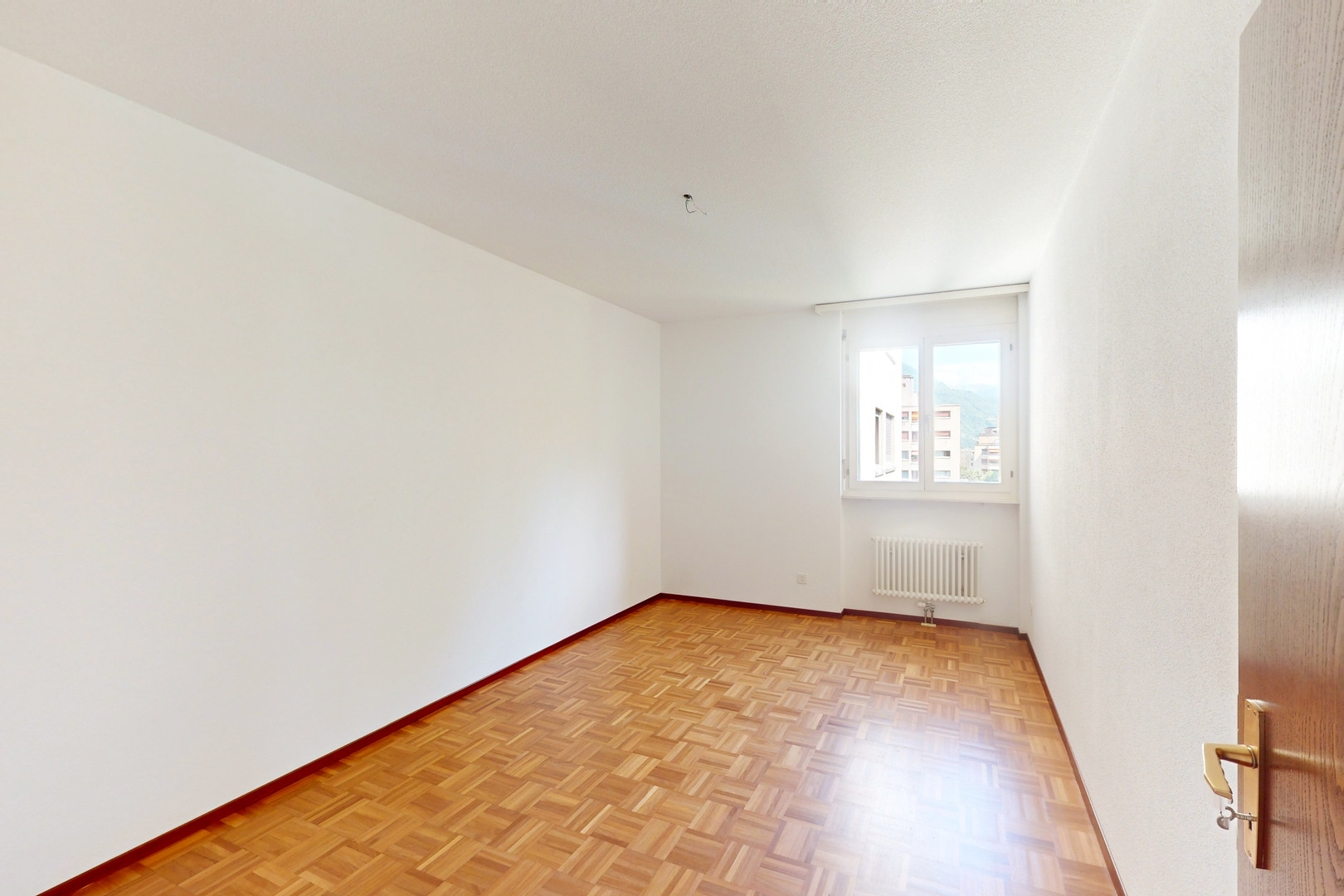 Leeres, helles Zimmer mit Parkettboden