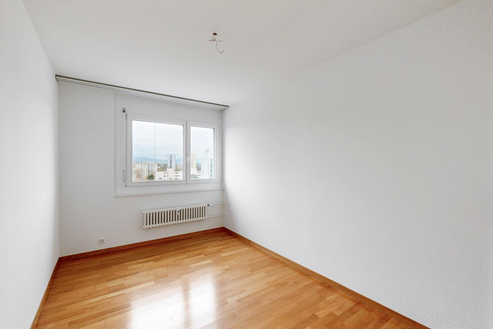 Leerer heller Raum mit Parkett und Fensterblick