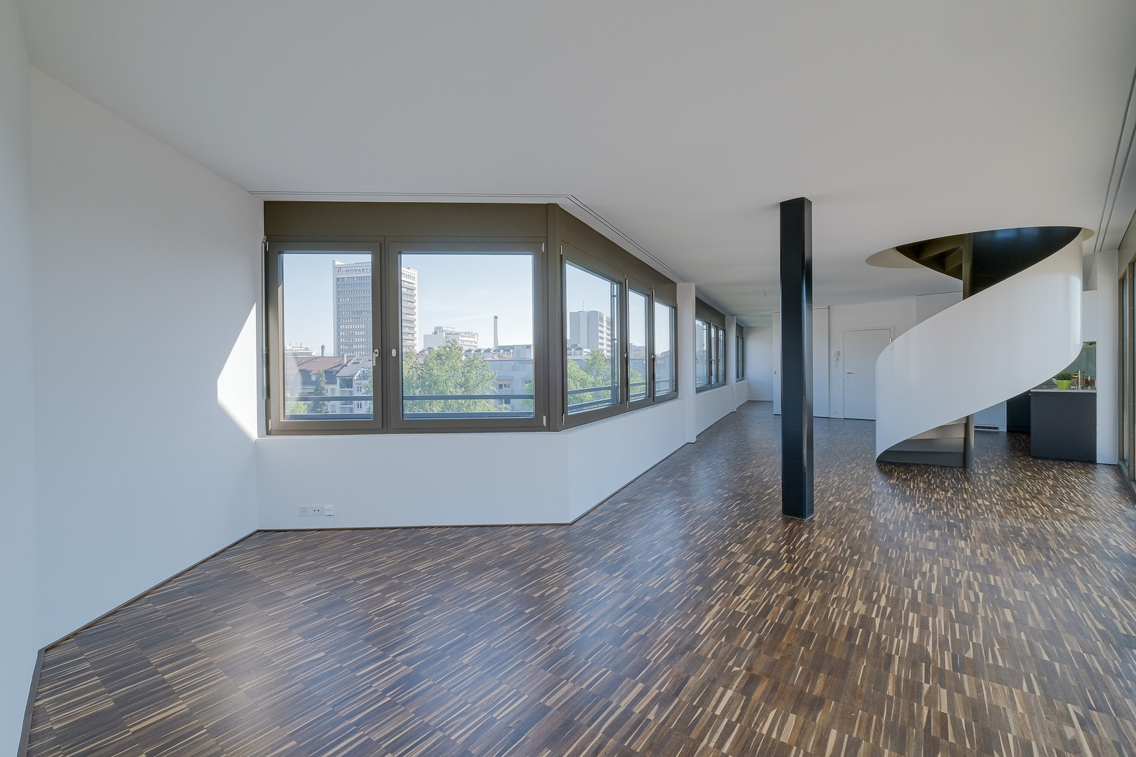 Großer heller Wohnraum mit Panoramafenstern und Wendeltreppe