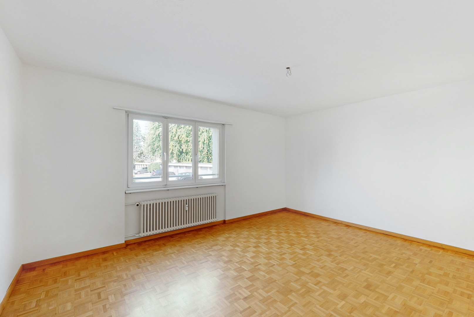 Leerer Wohnraum mit Fenster und Heizkörper