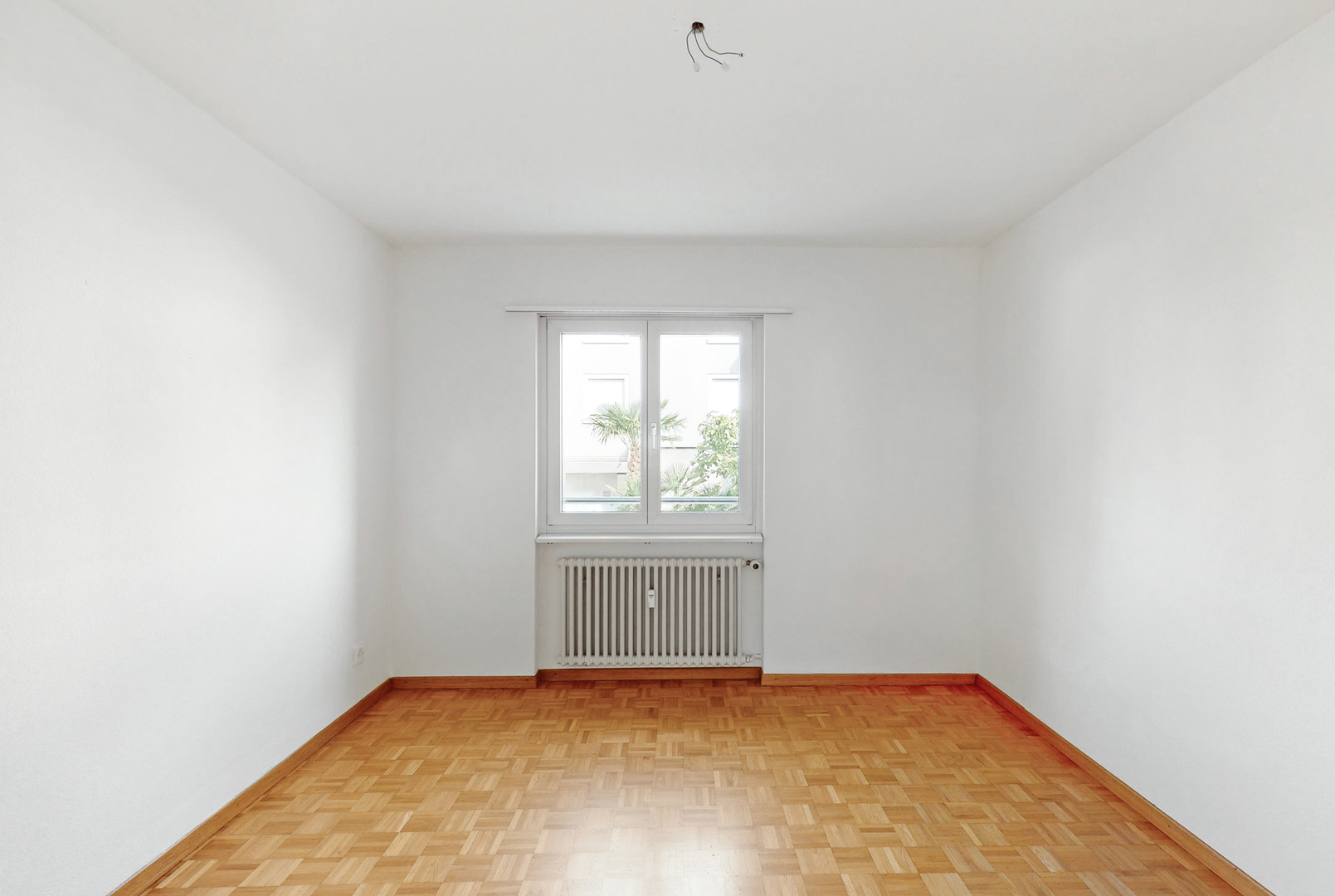 Leerer, heller Raum mit Parkettboden