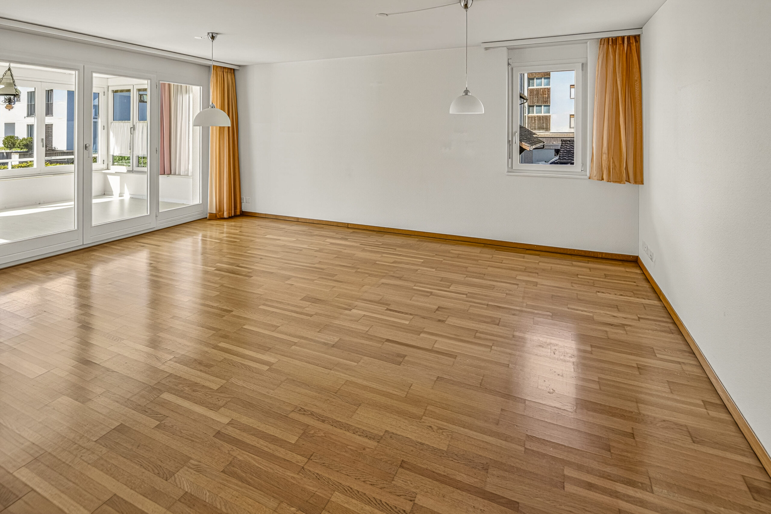 Leerer heller Wohnraum mit Holzparkett