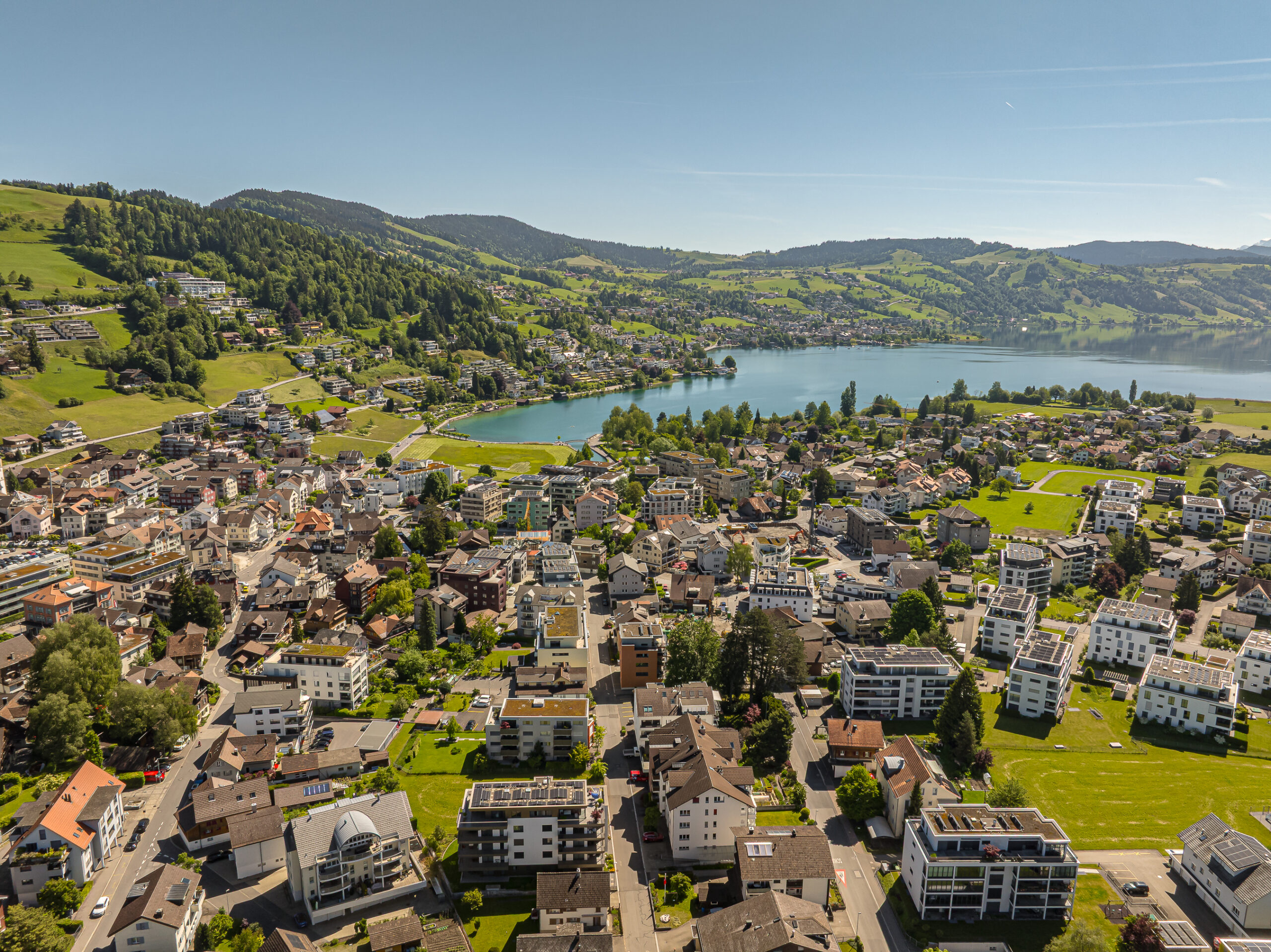 Luftaufnahme einer Seelandschaft mit Stadt und Bergen