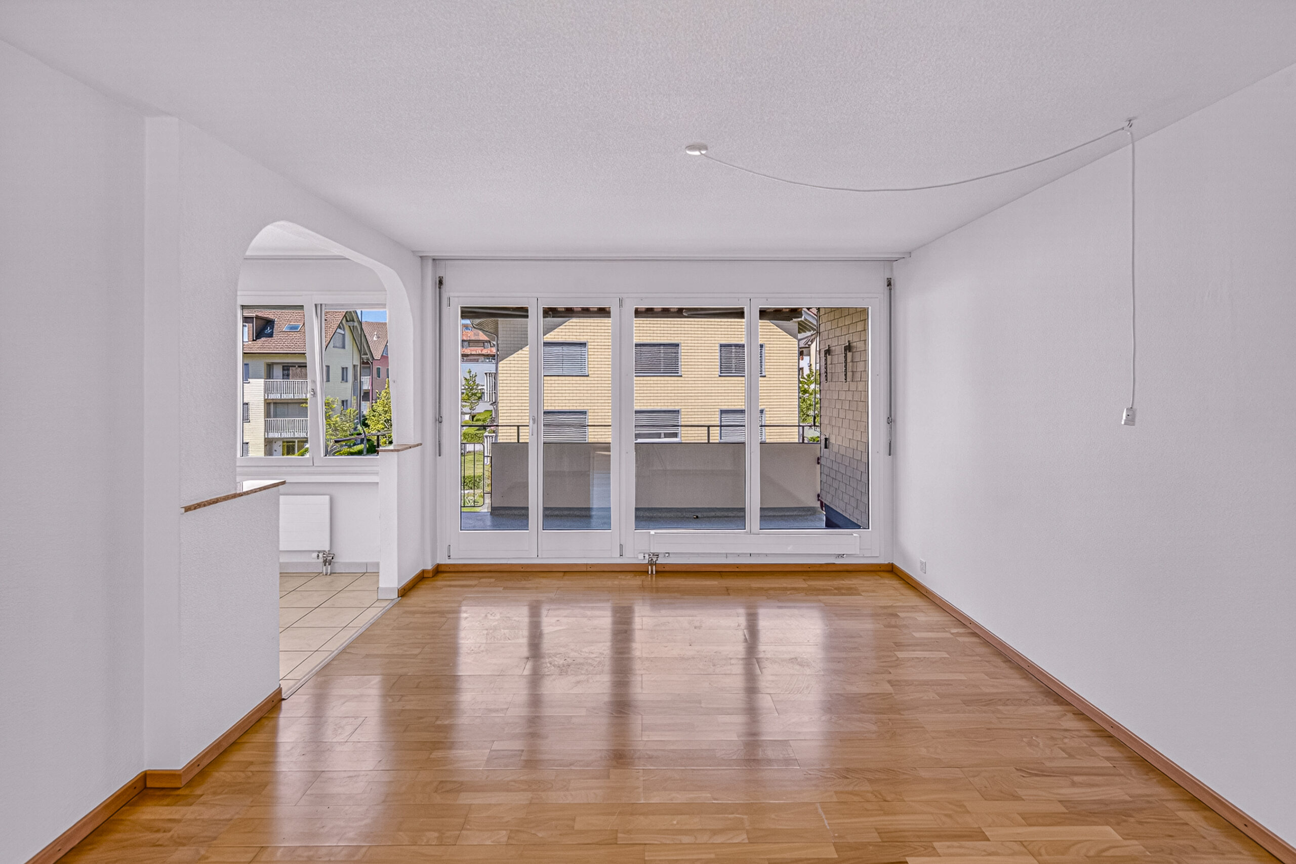 Leerer Wohnraum mit Balkonzugang