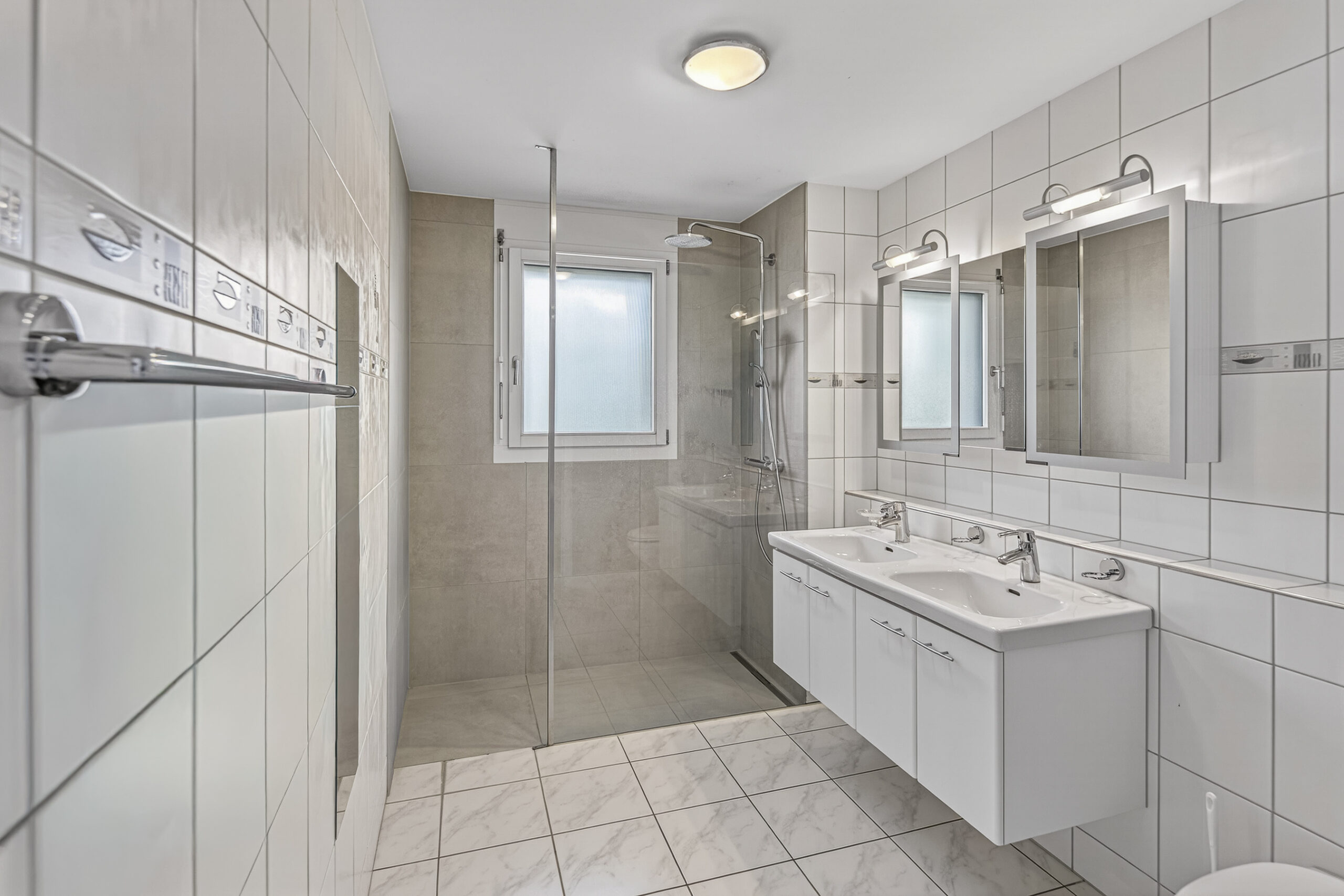 Modernes Badezimmer mit Doppelwaschtisch und Glasdusche