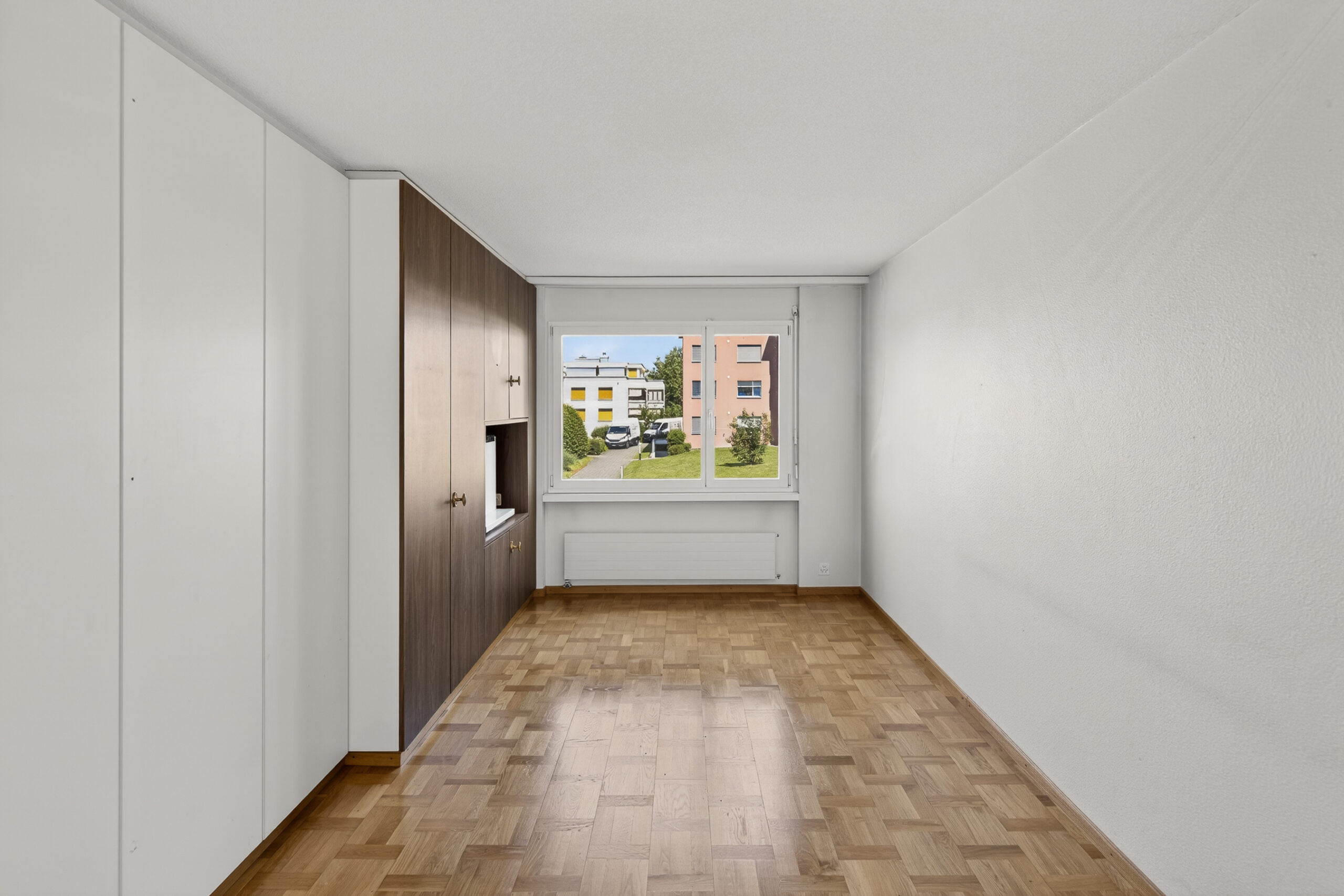 Helles Zimmer mit Fenster und Einbauschrank