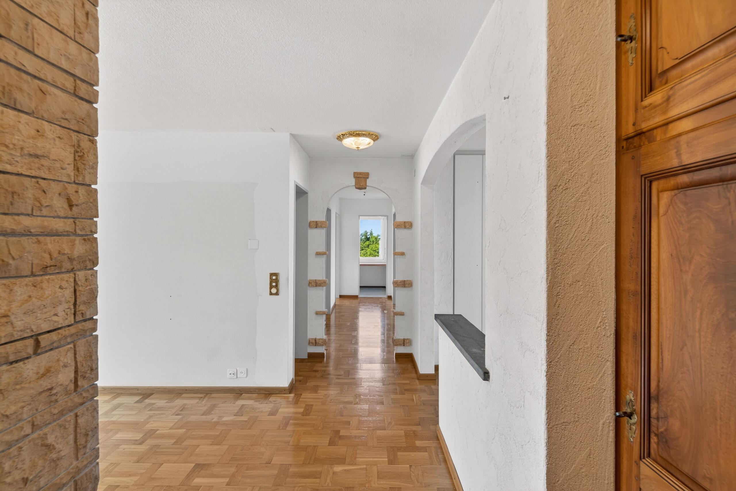 Flur mit Holzboden und Durchgang zum Fenster
