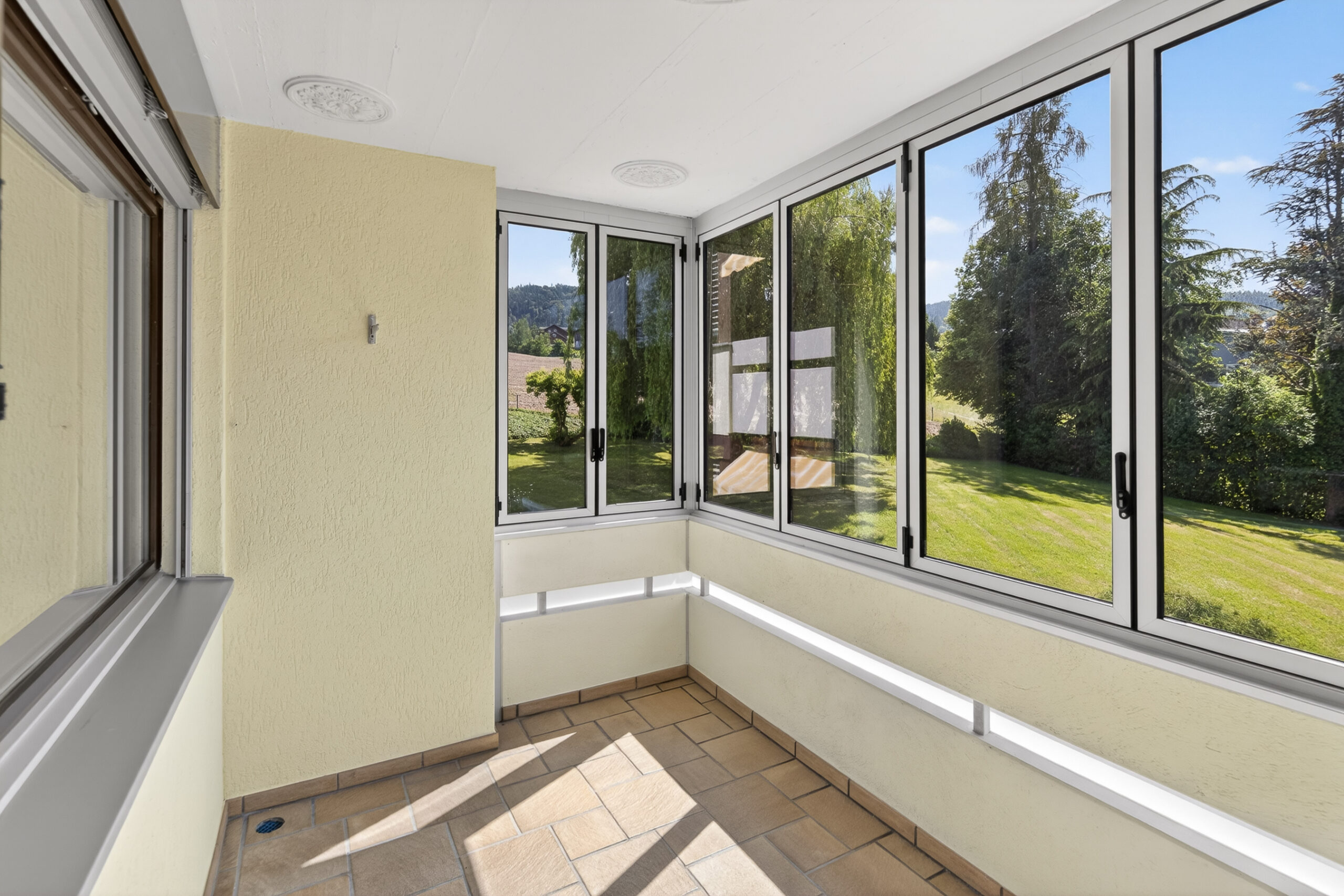 Verglaster Balkon mit Gartenblick