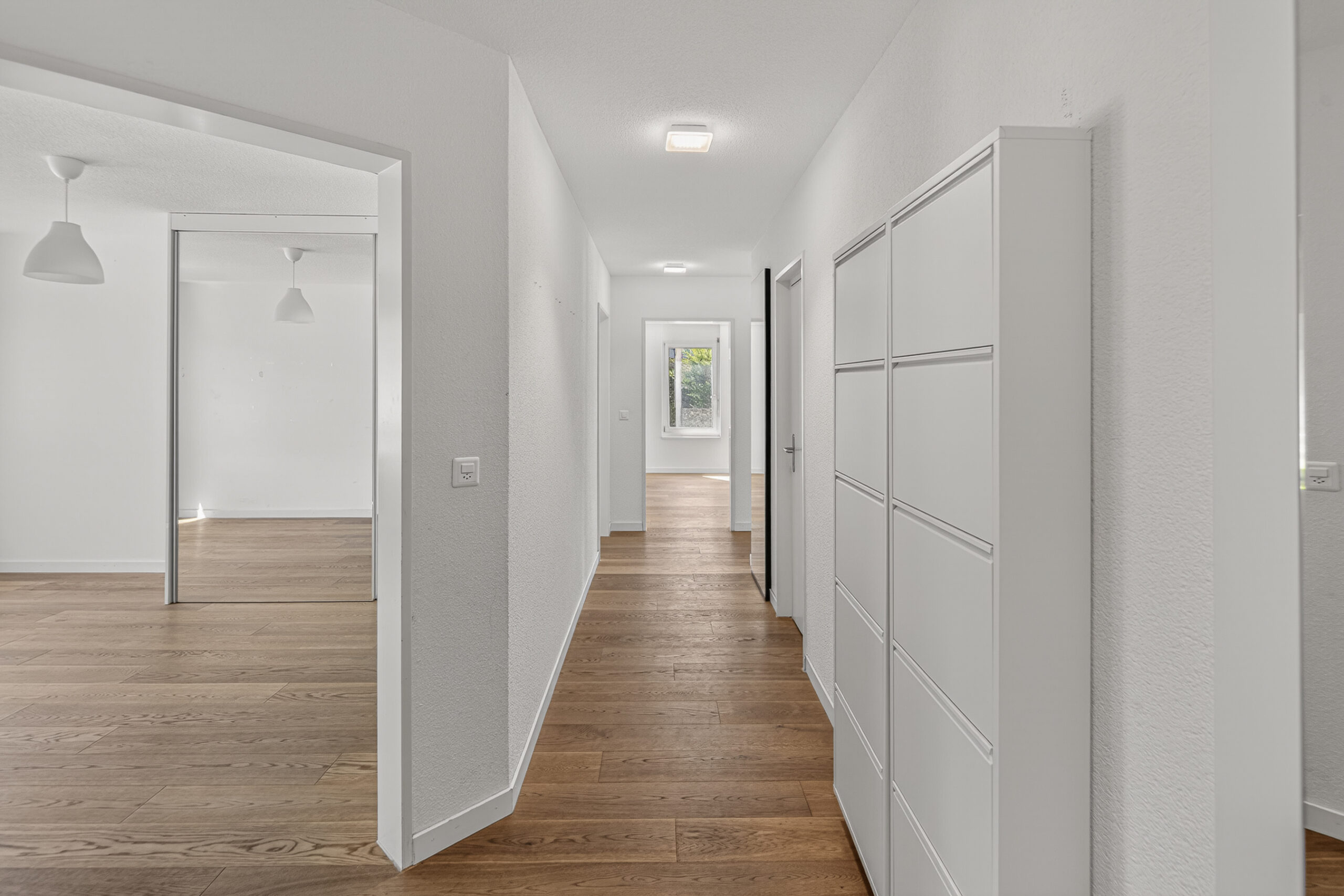Heller Flur mit Holzboden und Einbauschrank