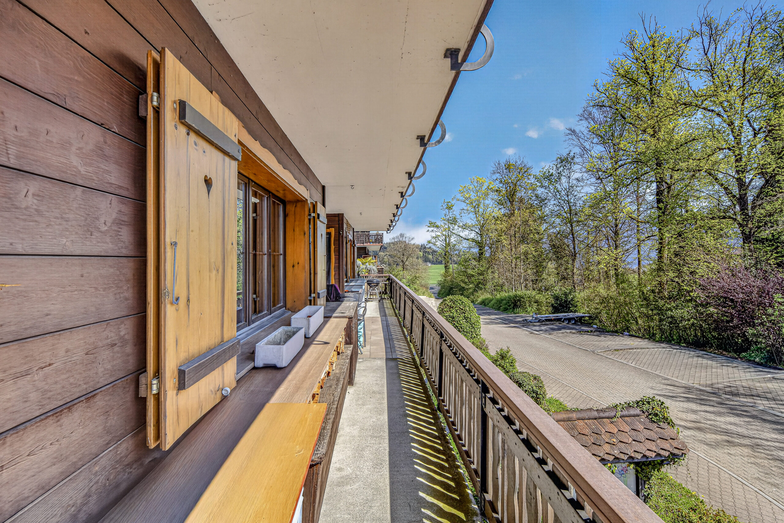 Balkon mit Holzverkleidung und Ausblick ins Grüne