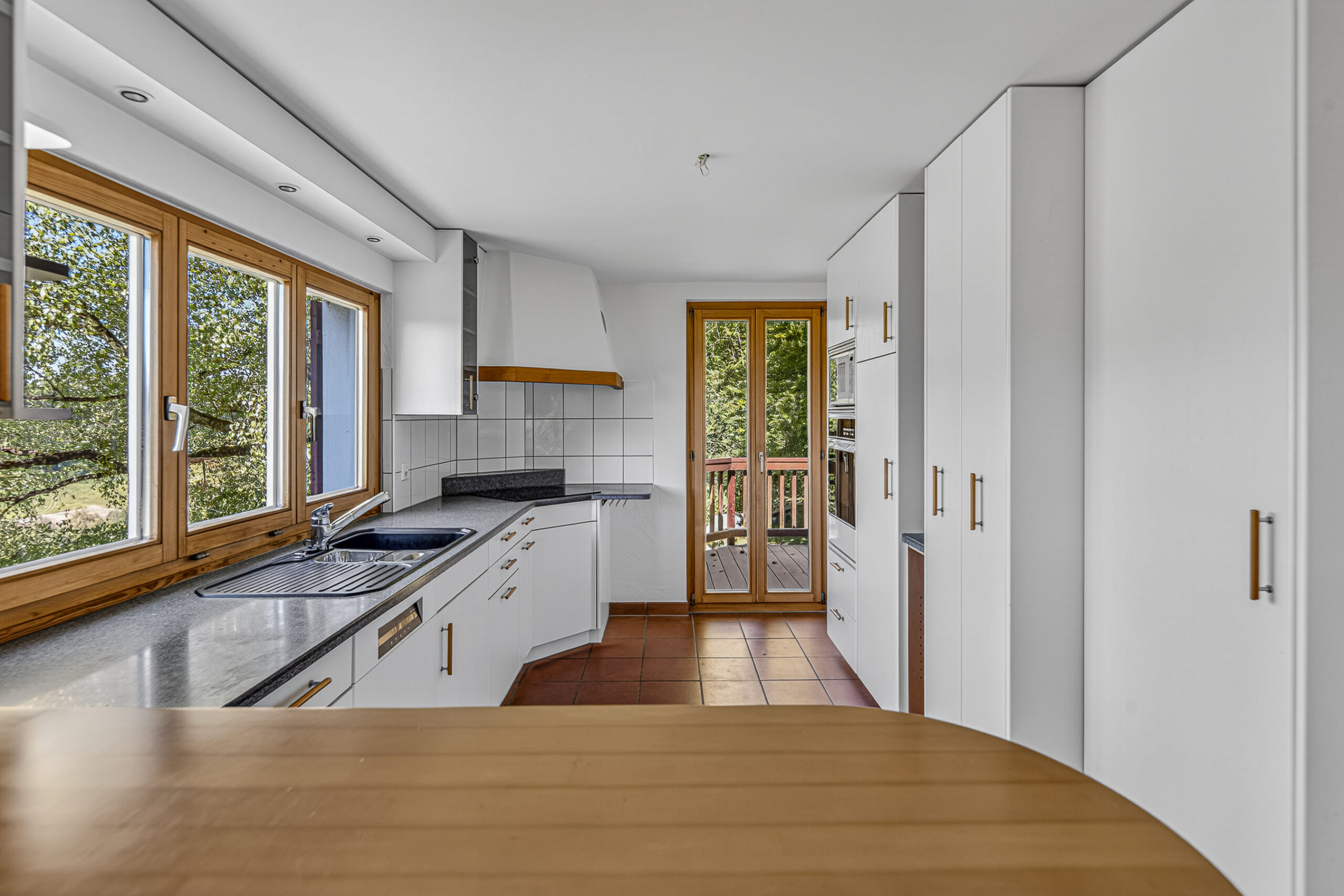 Helle Küche mit Holzfenstern und Terrassentür