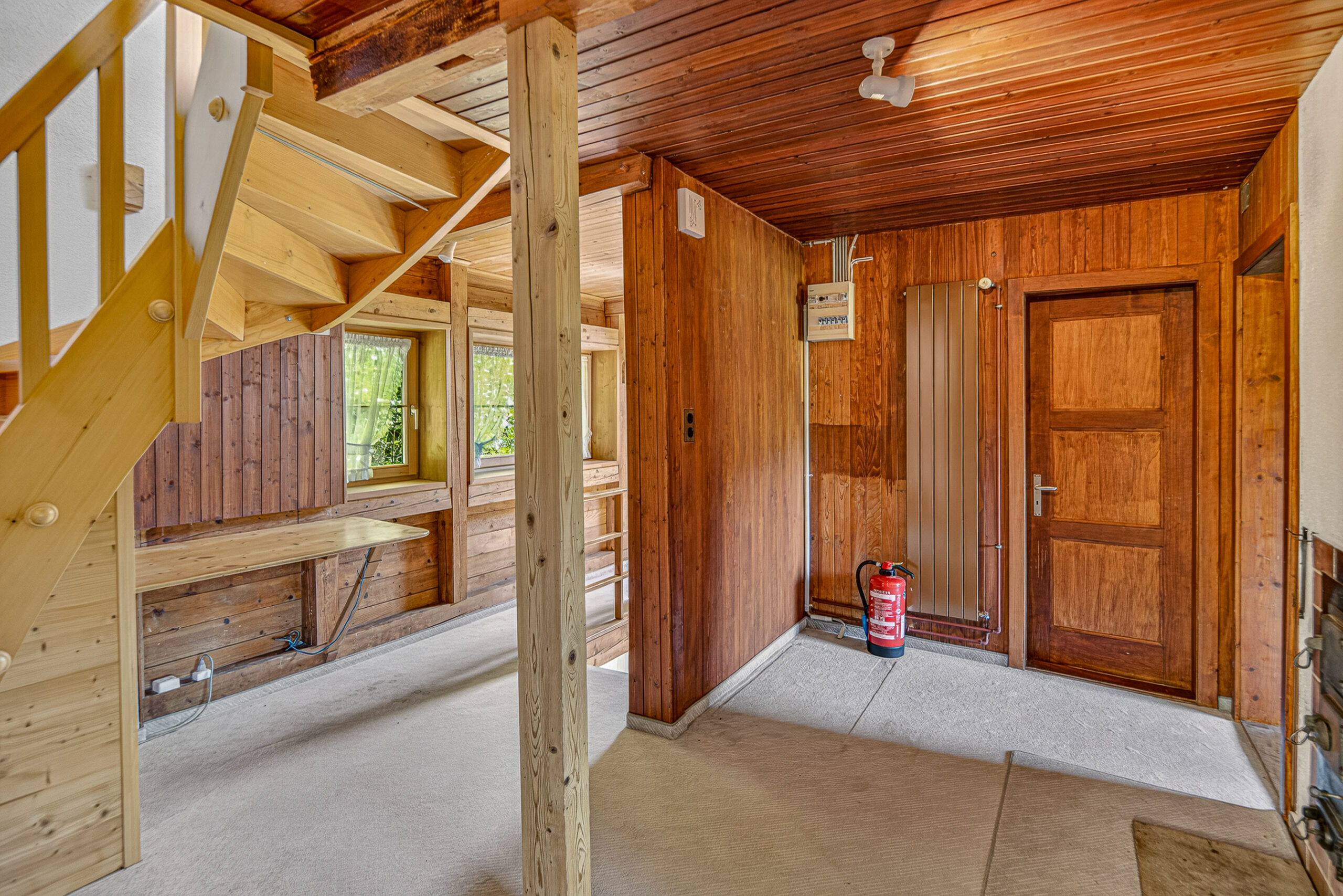 Rustikaler Innenraum mit Holzverkleidung und Treppe