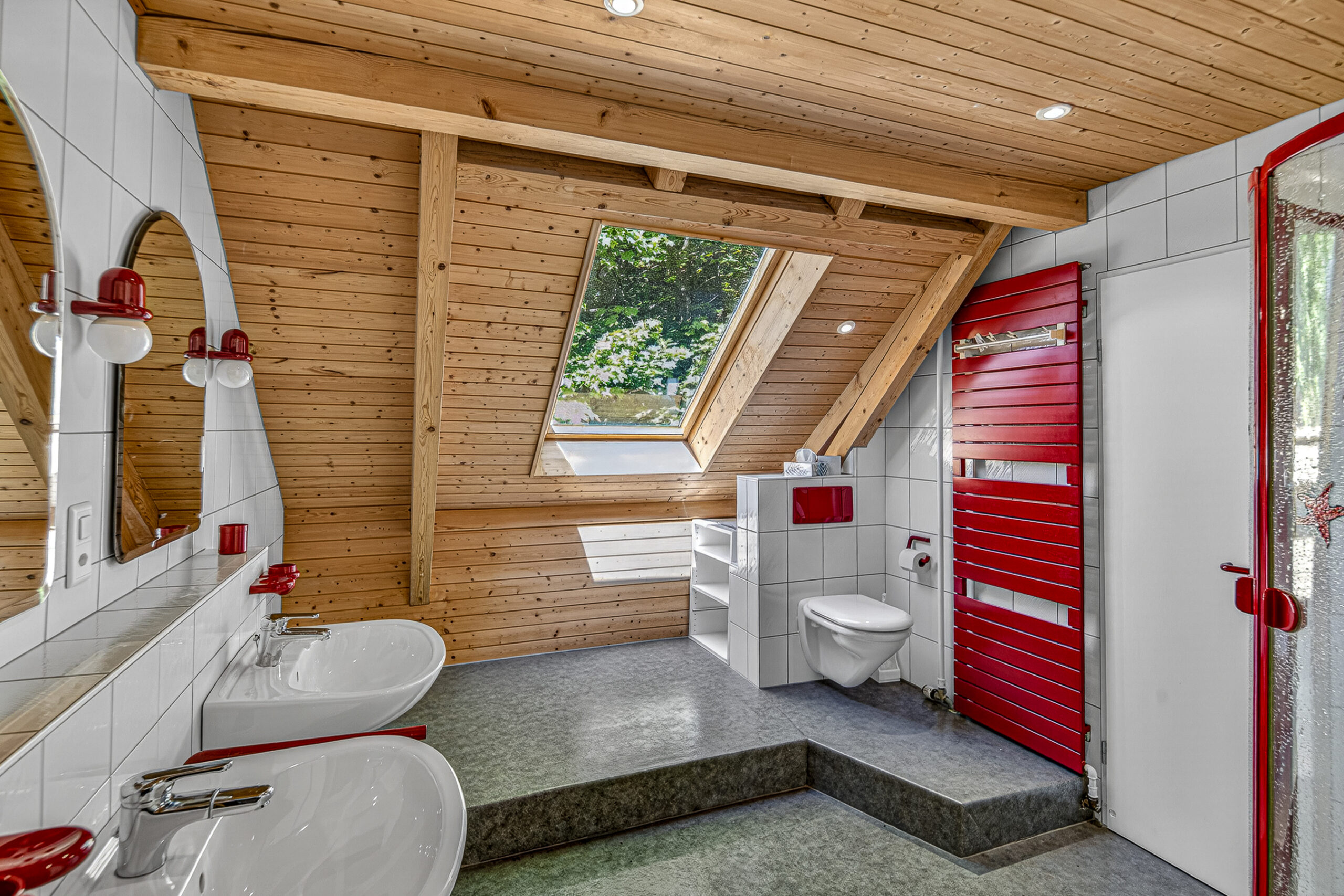Helles Dachgeschossbad mit Holzdecke und roten Akzenten