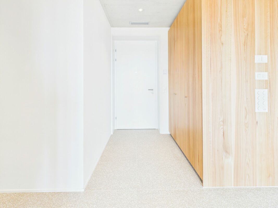 Heller Flur mit Einbauschrank und weißer Tür