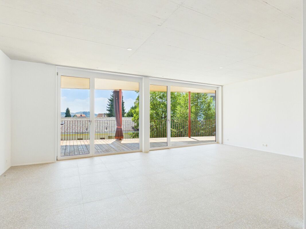 Heller leerer Wohnraum mit großer Fensterfront