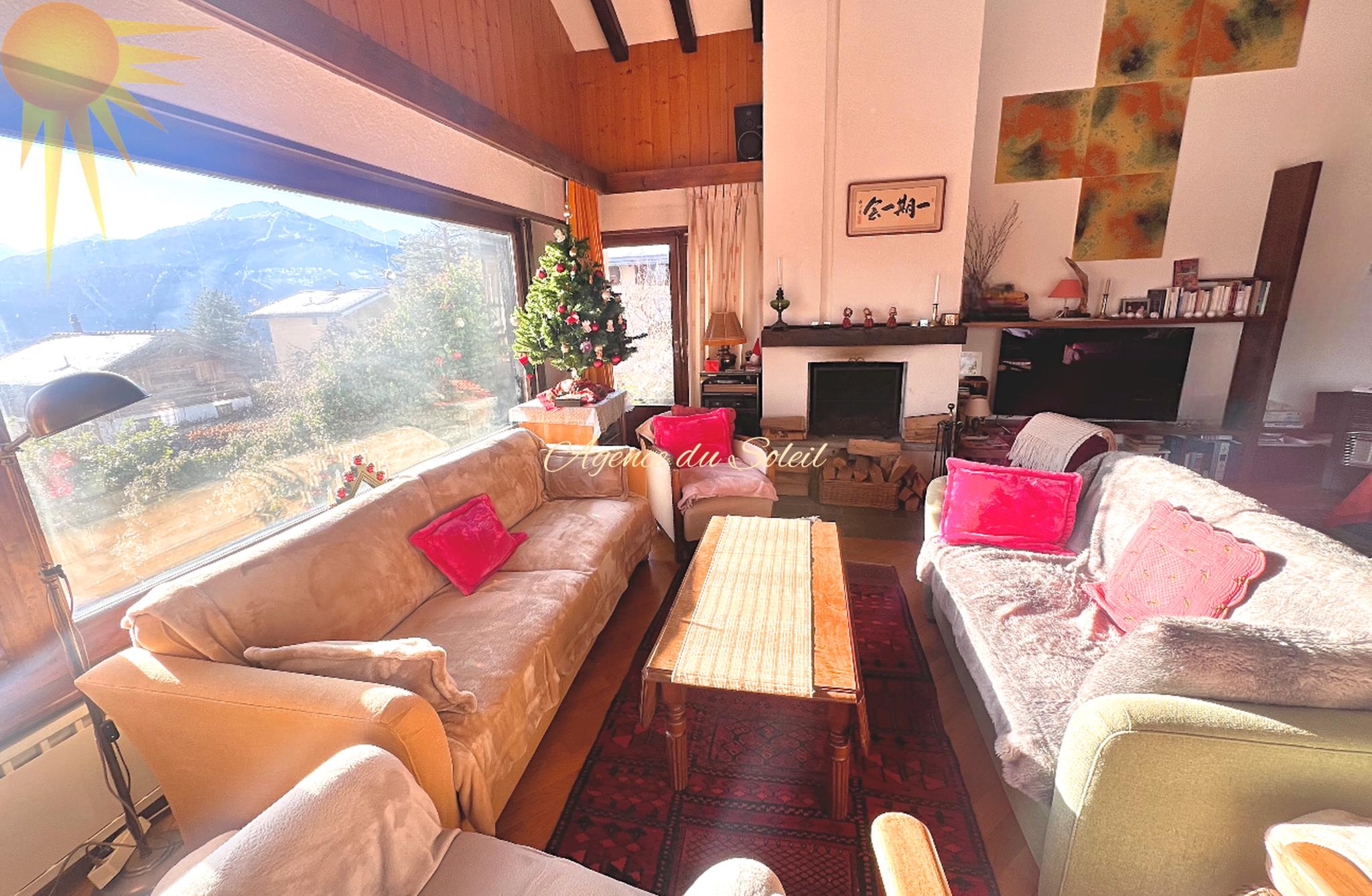 Helles Wohnzimmer mit Kamin und Bergblick