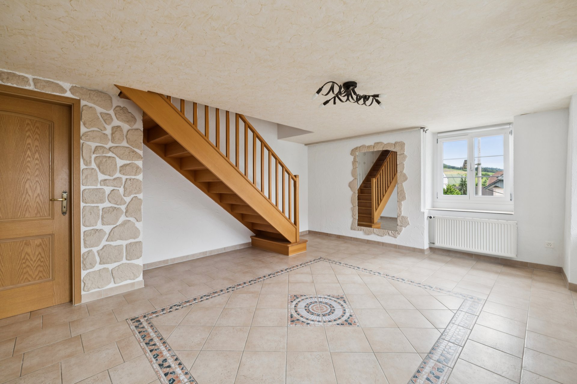 Heller Eingangsbereich mit Holztreppe