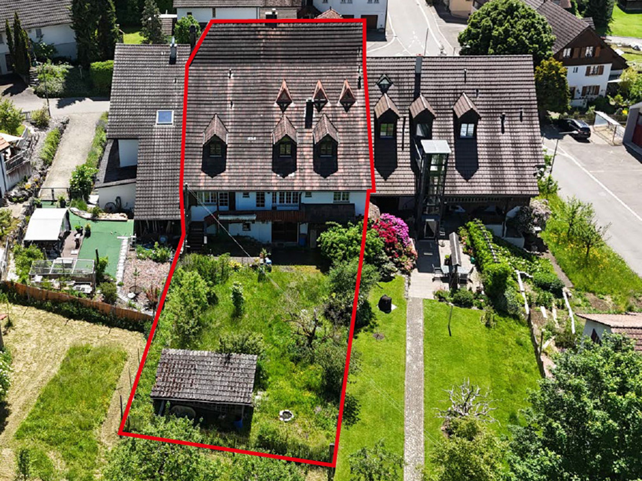 Ausschließliches Luftbild eines Wohnhauses mit großem Garten und rotem Umriss