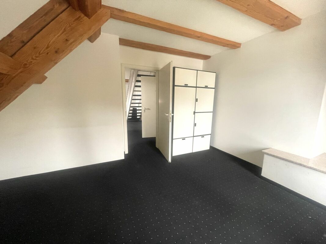 Dachgeschosszimmer mit sichtbaren Holzbalken