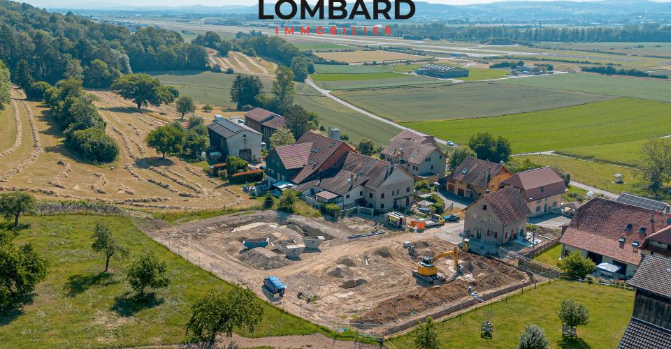 Luftaufnahme eines ländlichen Baugrundstücks mit Häusern und Feldern