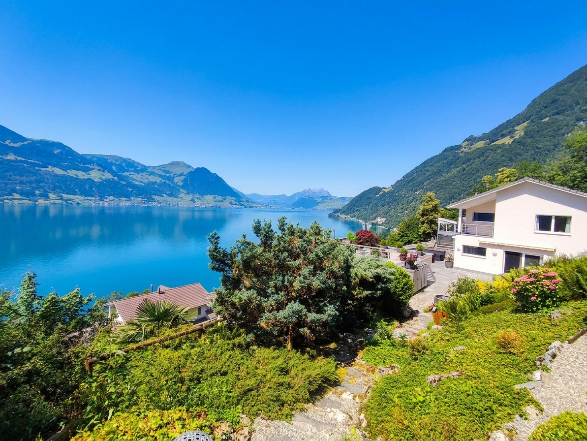 Seeblick von einer Hanglage mit Einfamilienhaus und Garten