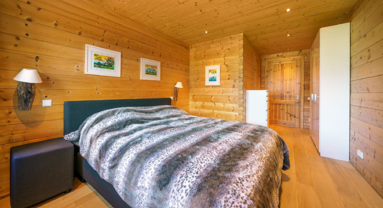 Holzverkleidetes Schlafzimmer mit Bett