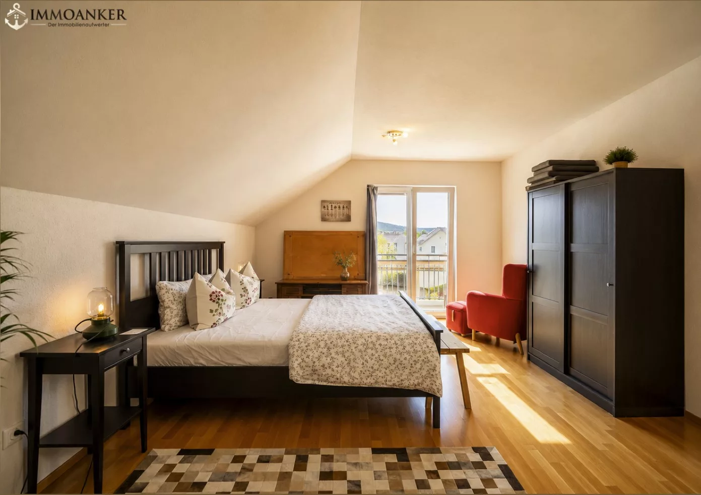 Schlafzimmer mit Dachschräge und Balkonblick