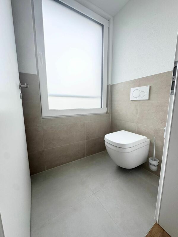 Modernes Gäste-WC mit Wand-WC und Fenster