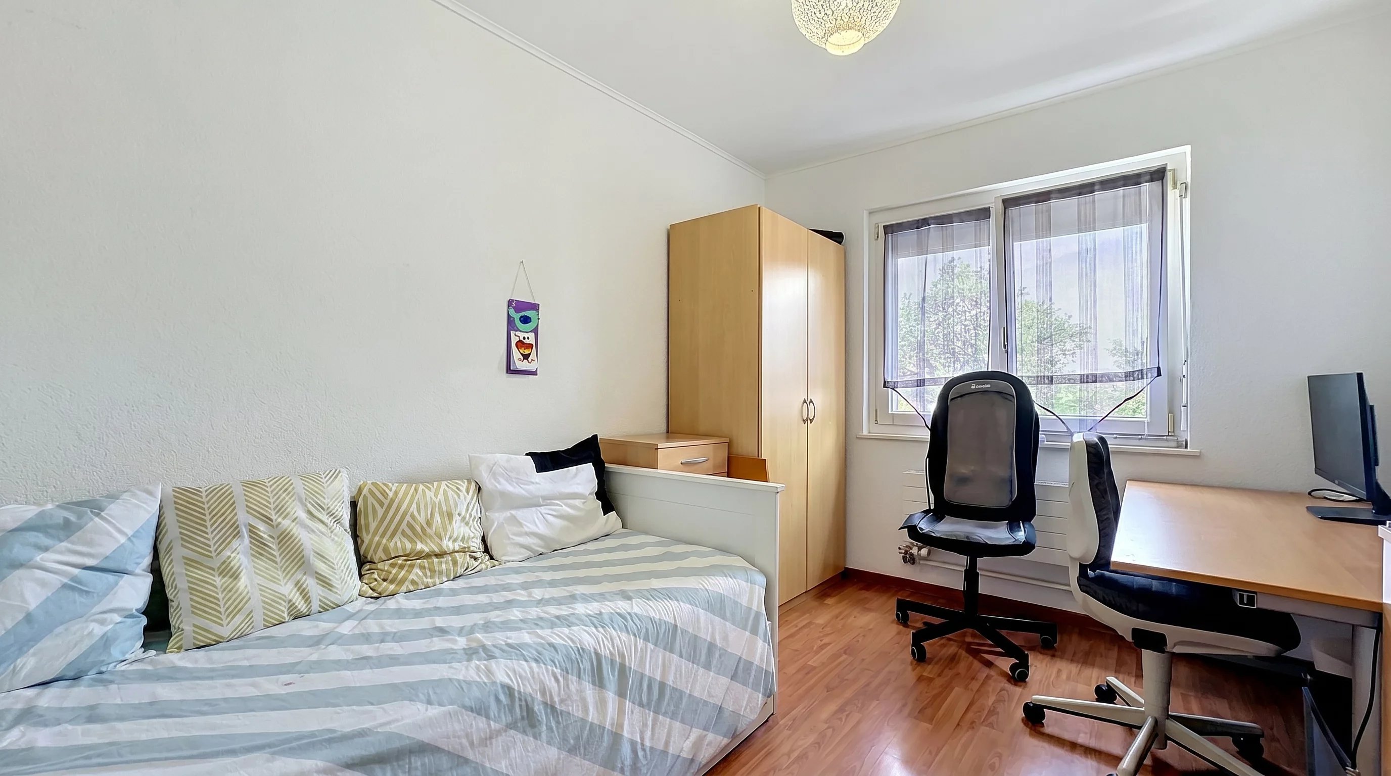 Helles Schlafzimmer mit Schreibtisch und Kleiderschrank