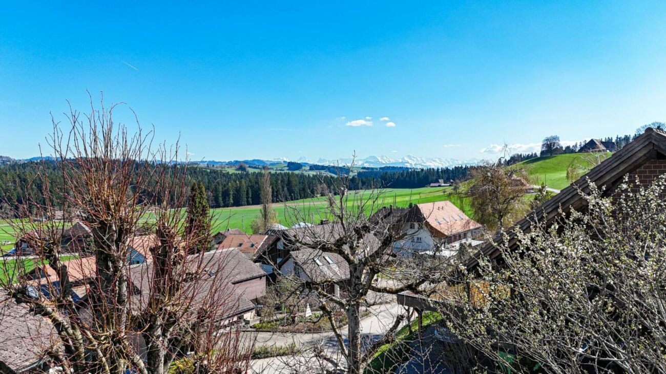 Landschafts- und Dorfblick mit Alpenpanorama