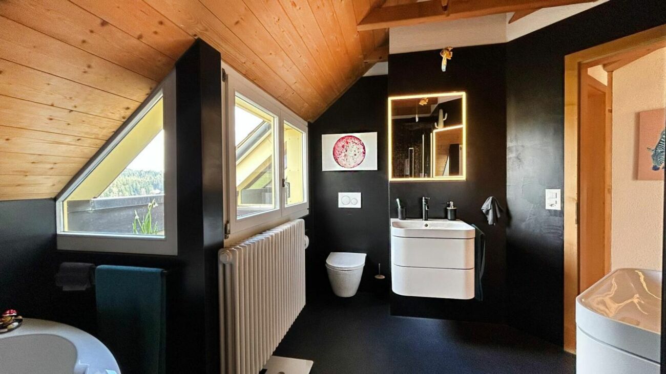 Dachgeschoss-Badezimmer mit dunkler Akzentwand
