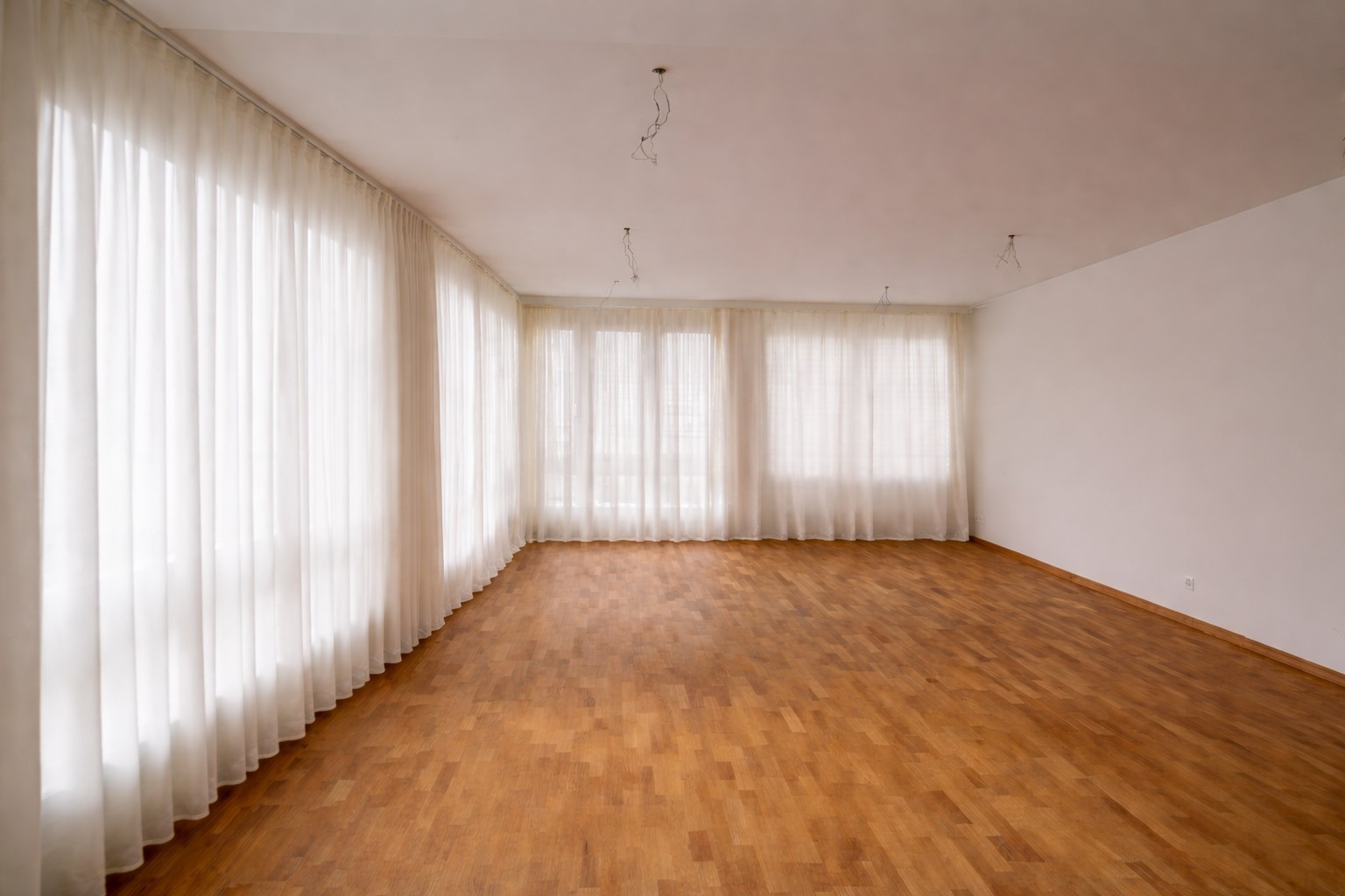 Leerer Wohnraum mit großen Fenstern