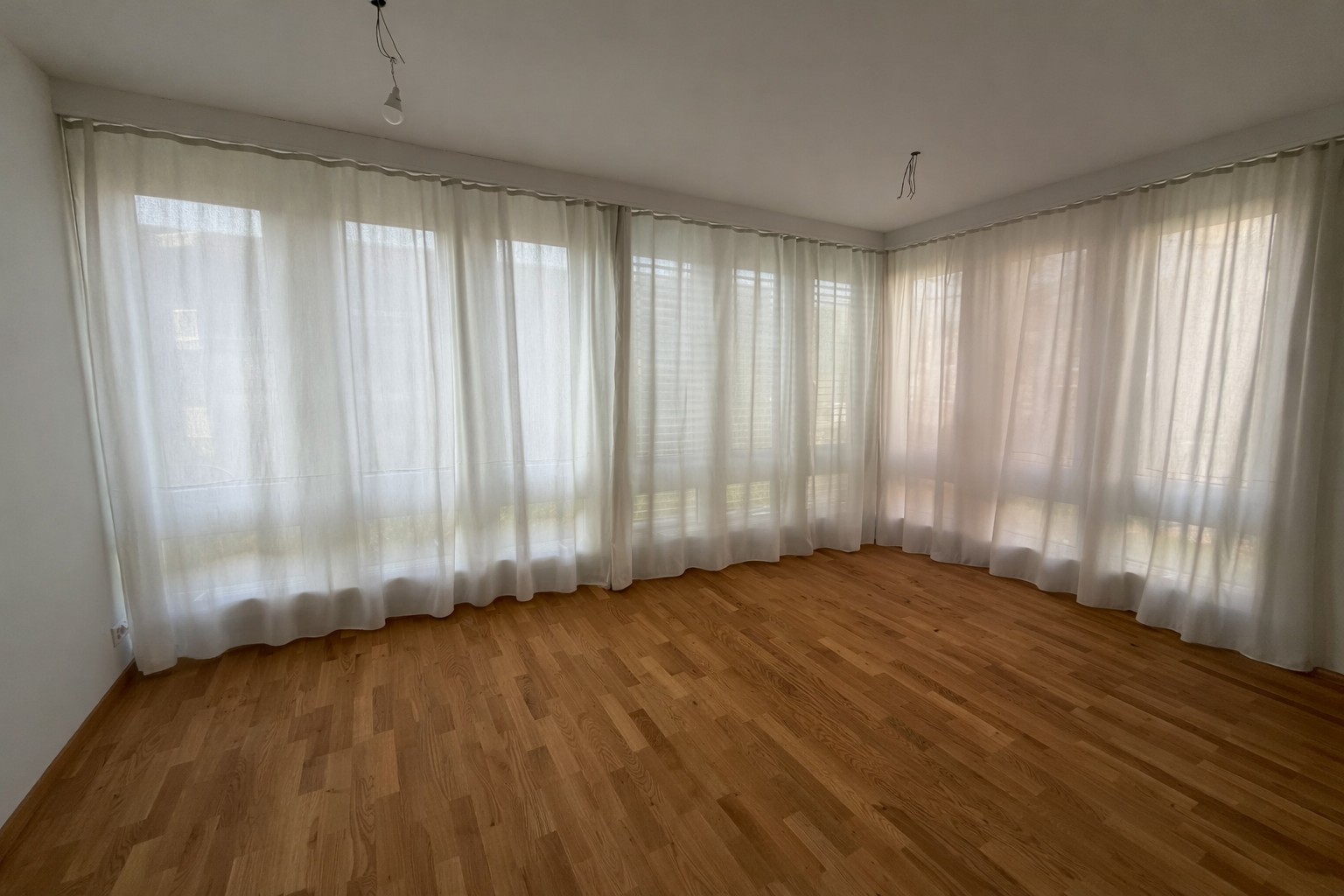 Heller leerer Wohnraum mit großen Fenstern