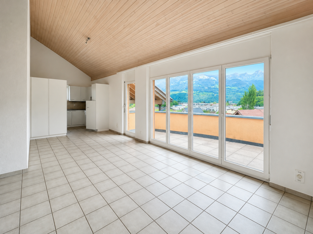 Heller Wohnraum mit Balkon und Bergblick