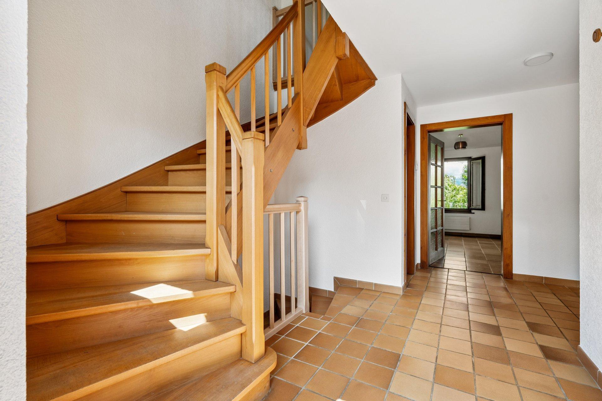 Heller Eingangsbereich mit Holztreppe