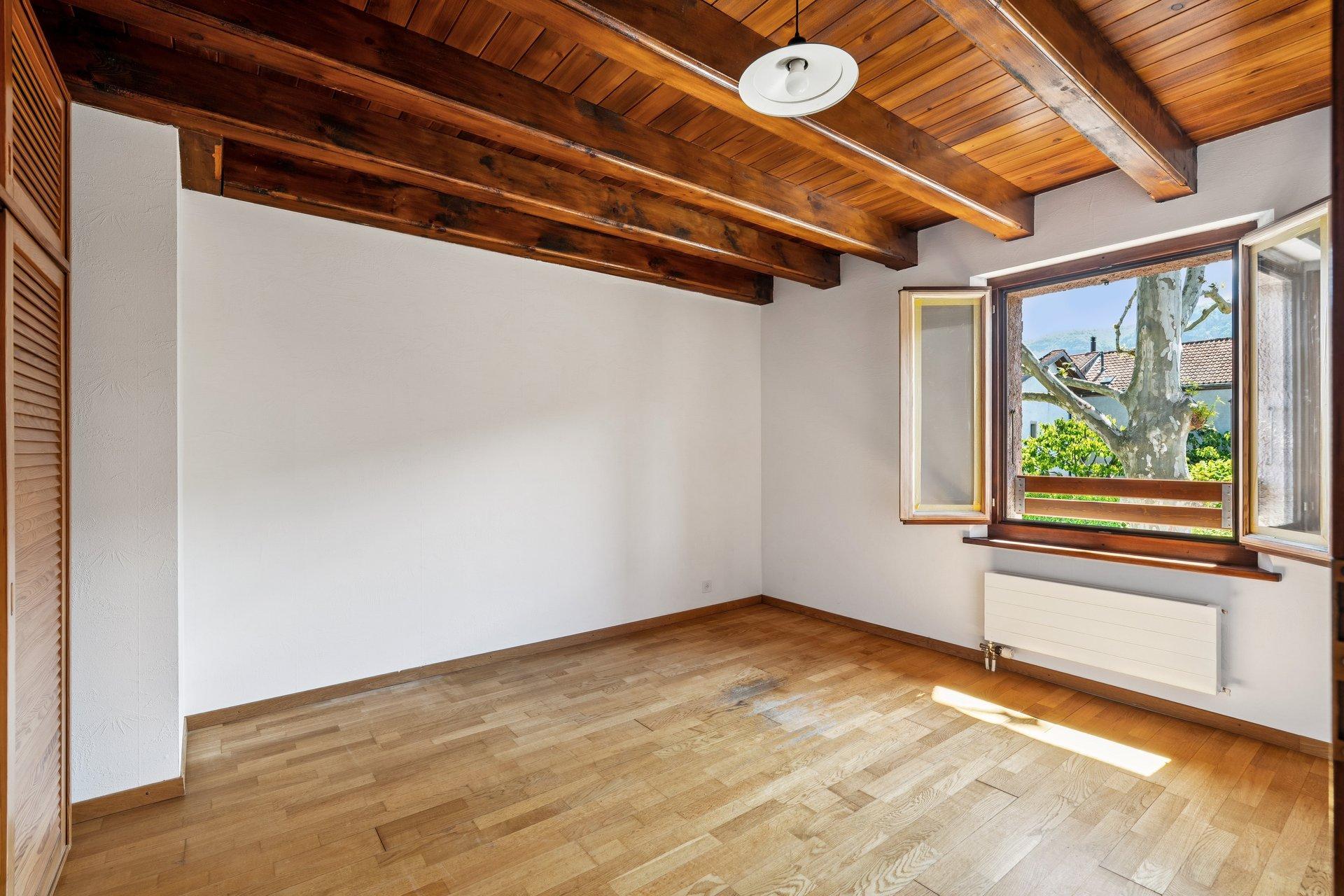 Leerer Raum mit Holzbalkendecke und Fensterblick