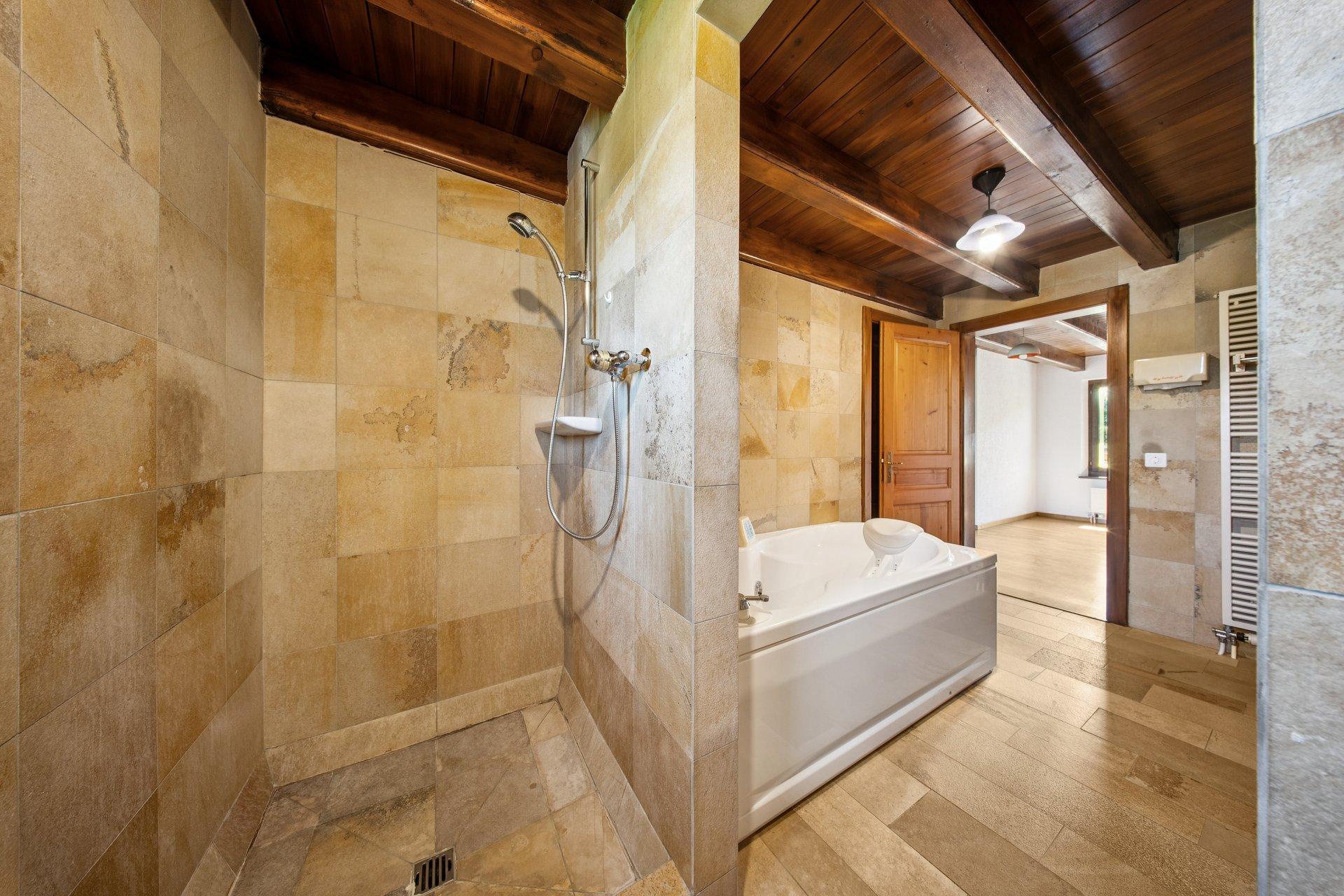 Rustikales Bad mit Holzdecke und Natursteinoptik