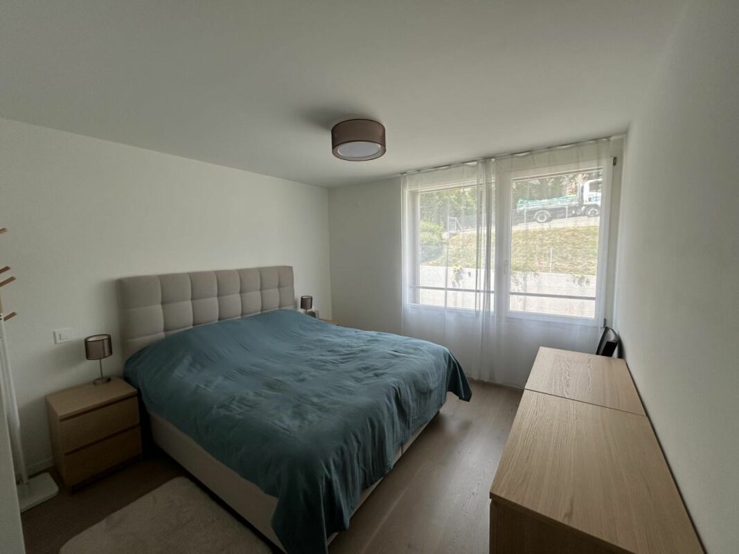Helles Schlafzimmer mit Doppelbett und Fensterfront