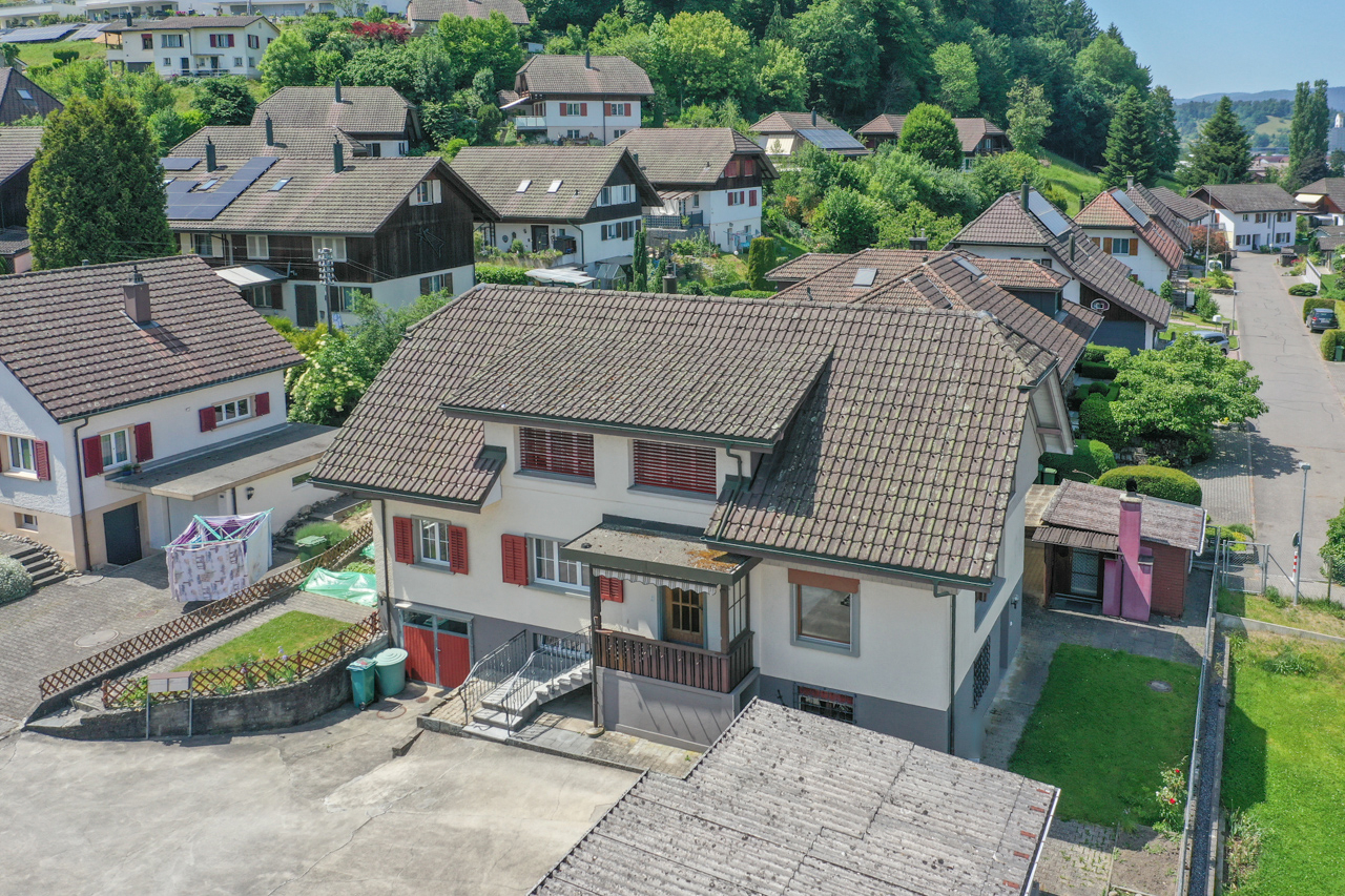 Luftaufnahme eines Wohnhauses in grüner Hanglage