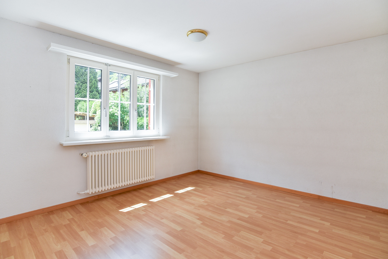 Leerer heller Raum mit Fenster und Heizkörper
