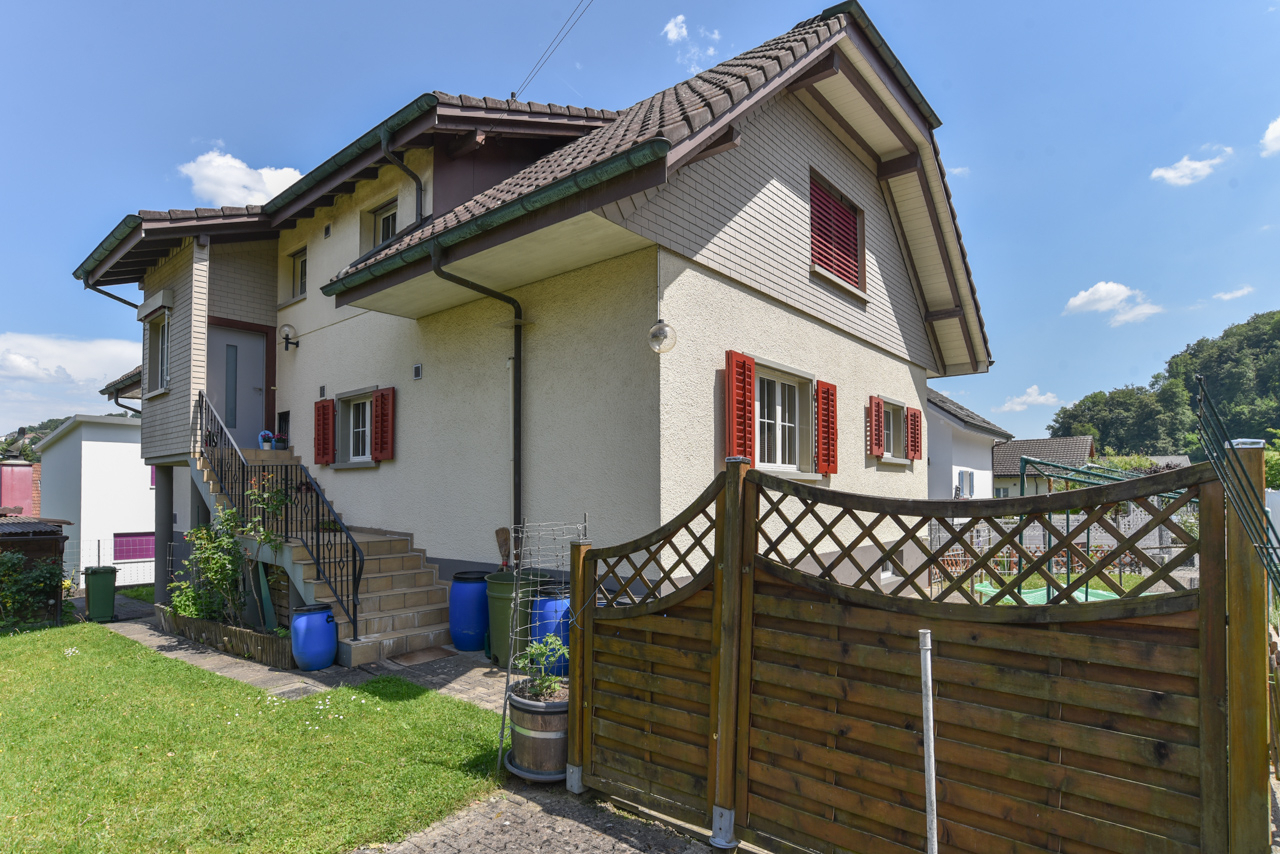 Einfamilienhaus mit Garten und Holzzaun