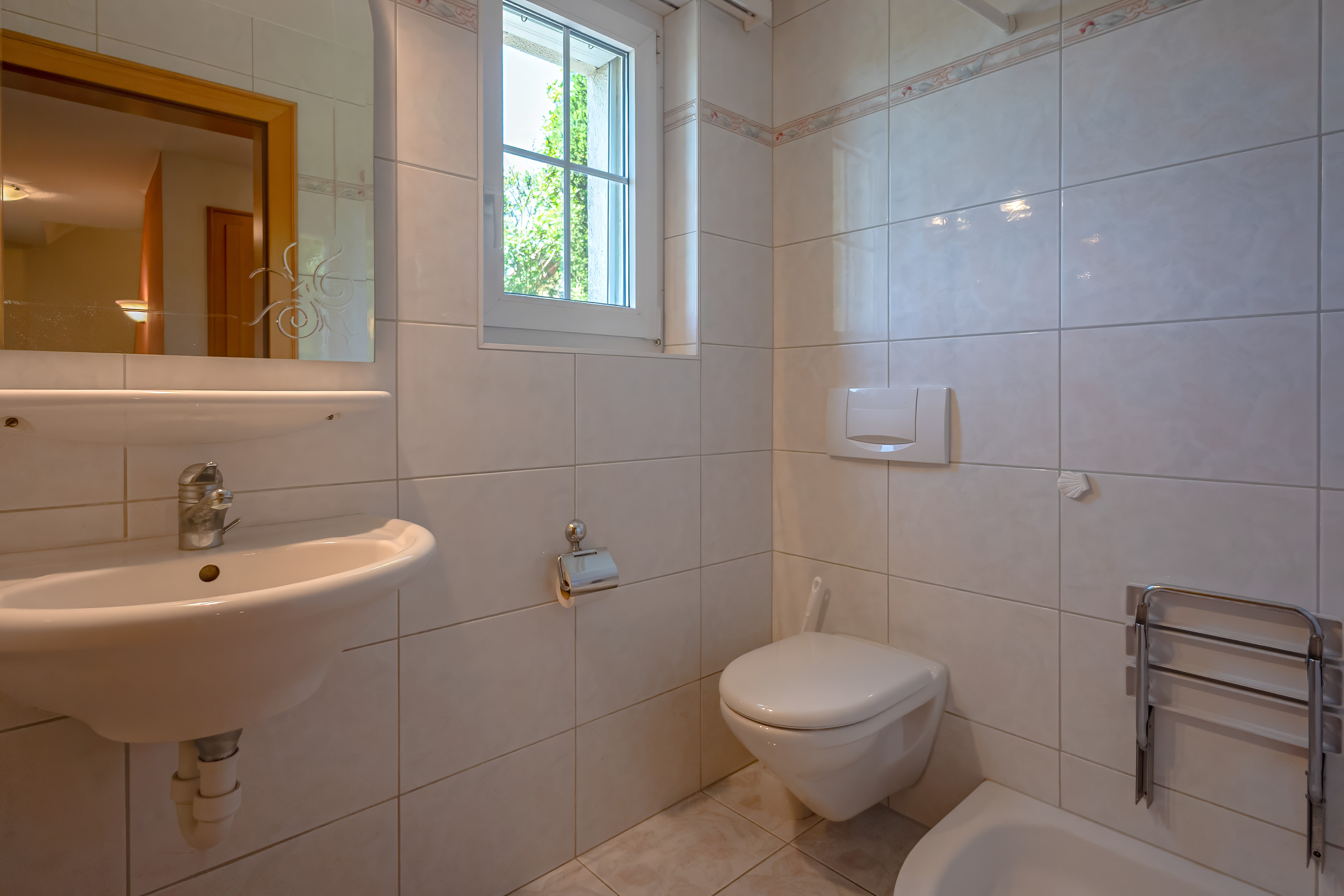 Gäste-WC mit Fenster und Wandfliesen
