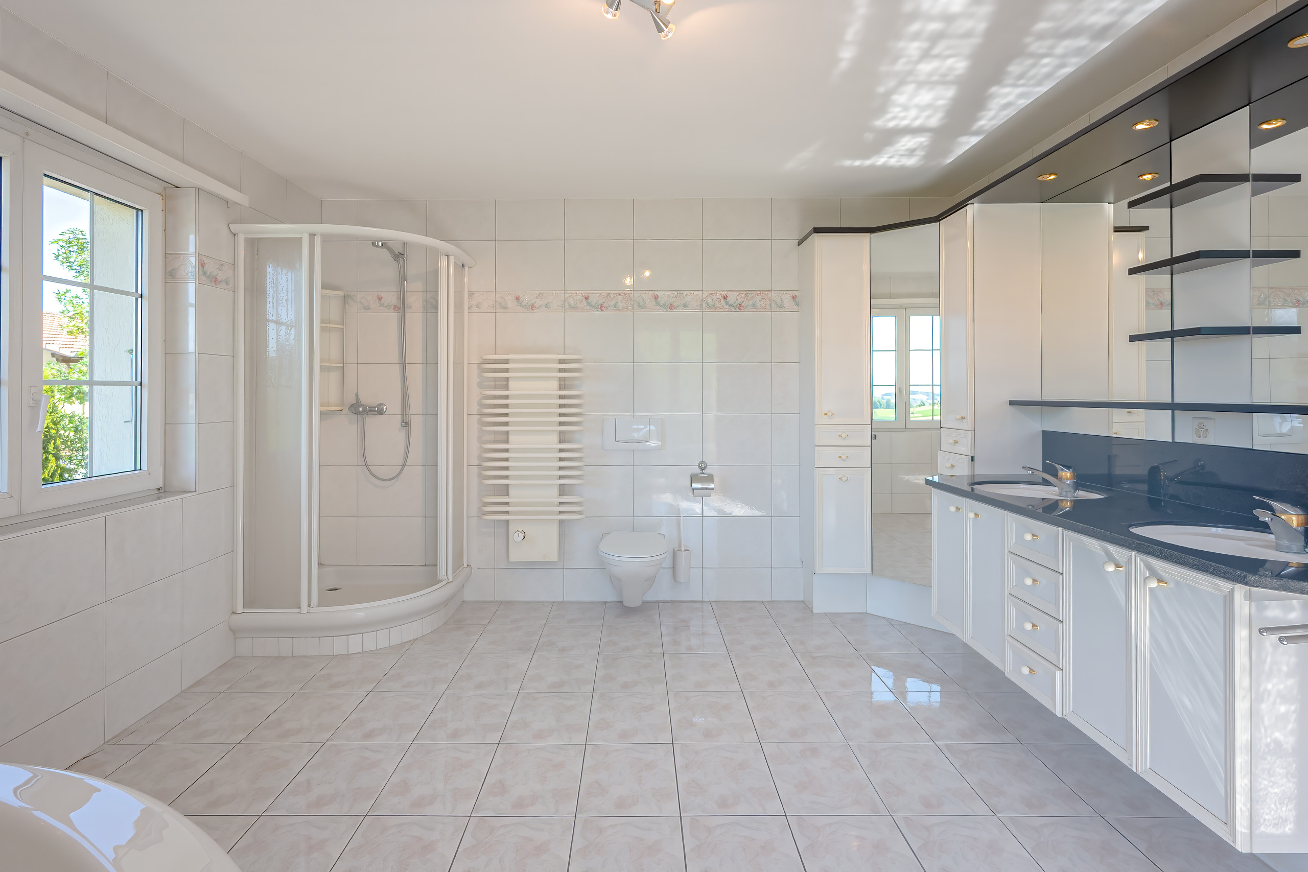 Helles, modernes Badezimmer mit Dusche, Doppelwaschtisch und WC